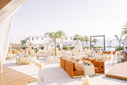 Festive tables stand around a stage on the open sunny terrace. High quality photo