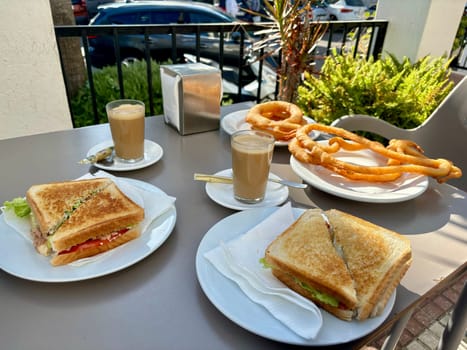 Spanish breakfest - coffee cortado, sandwich and churros in outdoor summer terrace. High quality photo