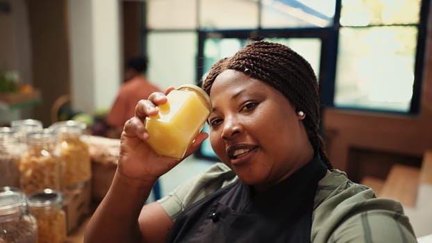 POV of merchant recording promotional ad to attract clients at organic grocery store, advertising natural ethically sourced produce and food essentials. African american business owner. Handheld shot.