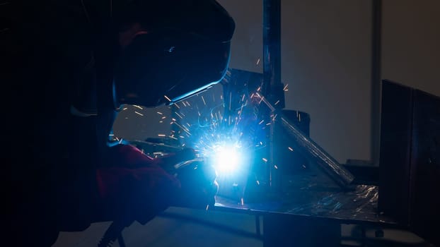 Competitions among welders. A man in a protective mask is welding