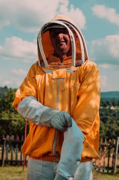 Beekeeper put on a protective beekeeping suit and preparing to enter the apiary.