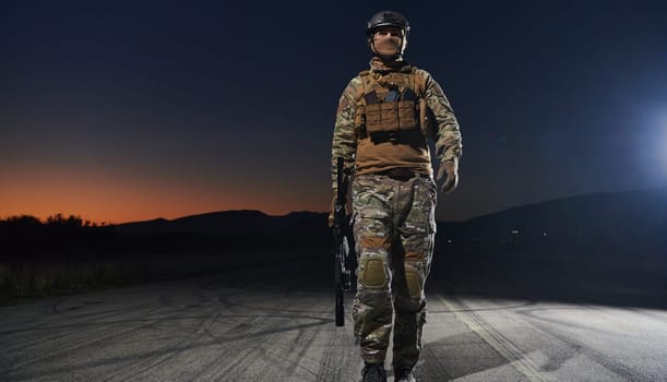 A professional soldier in full military gear striding through the dark night as he embarks on a perilous military mission.