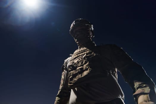 A professional soldier in full military gear striding through the dark night as he embarks on a perilous military mission.