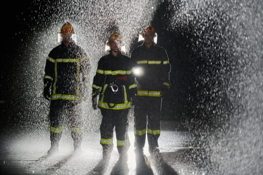 A group of professional firefighters marching through the rainy night on a rescue mission, their determined strides and fearless expressions reflecting their unwavering bravery and unwavering commitment to saving lives