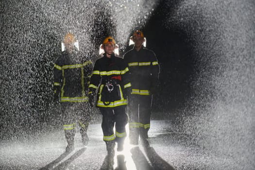 A group of professional firefighters marching through the rainy night on a rescue mission, their determined strides and fearless expressions reflecting their unwavering bravery and unwavering commitment to saving lives