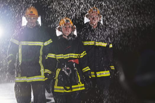 A group of professional firefighters marching through the rainy night on a rescue mission, their determined strides and fearless expressions reflecting their unwavering bravery and unwavering commitment to saving lives