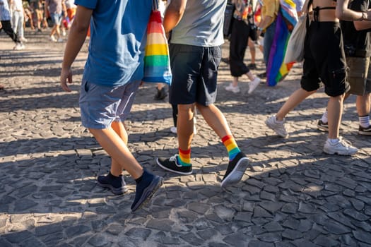 Low section of gay men walking on street during Pride Parade. People celebrate Gay Pride Parade in Lisbon. Happy and free individuals showing support for LGBTQ community.