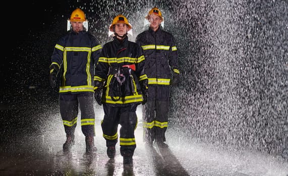 A group of professional firefighters marching through the rainy night on a rescue mission, their determined strides and fearless expressions reflecting their unwavering bravery and unwavering commitment to saving lives