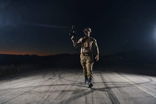 A professional soldier in full military gear striding through the dark night as he embarks on a perilous military mission.