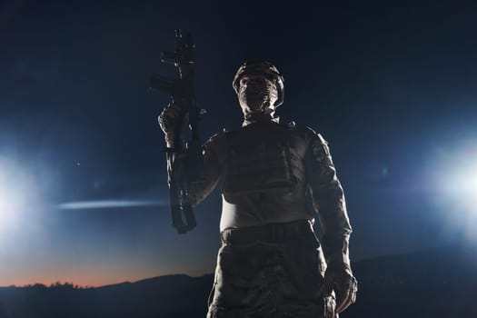 A professional soldier in full military gear striding through the dark night as he embarks on a perilous military mission.