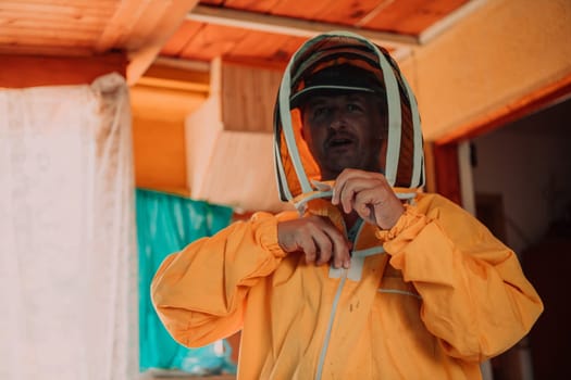 Beekeeper put on a protective beekeeping suit and preparing to enter the apiary.