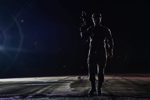 A professional soldier in full military gear striding through the dark night as he embarks on a perilous military mission.