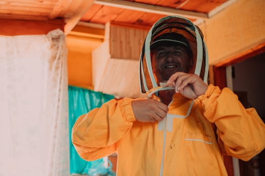 Beekeeper put on a protective beekeeping suit and preparing to enter the apiary.