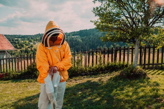 Beekeeper put on a protective beekeeping suit and preparing to enter the apiary.