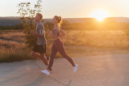 A handsome young couple running together during the early morning hours, with the mesmerizing sunrise casting a warm glow, symbolizing their shared love and vitality.