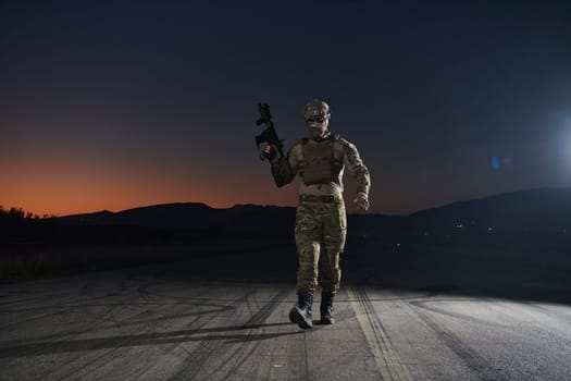 A professional soldier in full military gear striding through the dark night as he embarks on a perilous military mission.