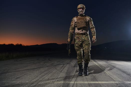 A professional soldier in full military gear striding through the dark night as he embarks on a perilous military mission.