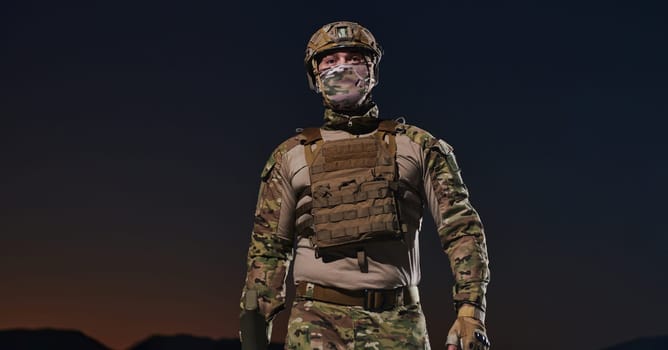 A professional soldier in full military gear striding through the dark night as he embarks on a perilous military mission.