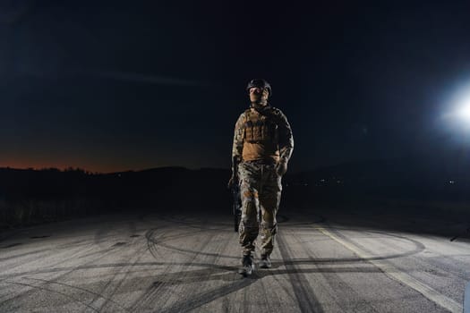 A professional soldier in full military gear striding through the dark night as he embarks on a perilous military mission.