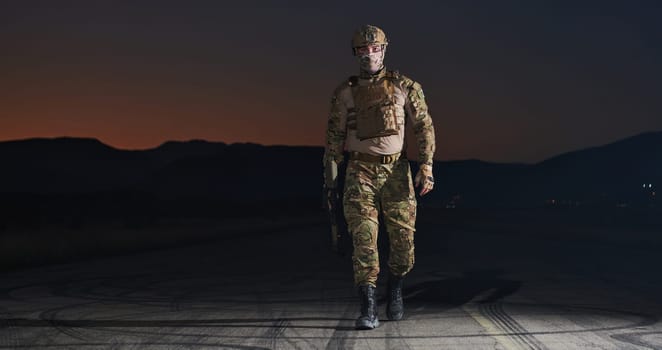 A professional soldier in full military gear striding through the dark night as he embarks on a perilous military mission.