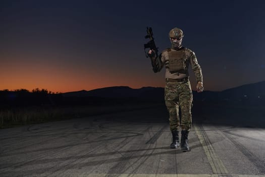 A professional soldier in full military gear striding through the dark night as he embarks on a perilous military mission.