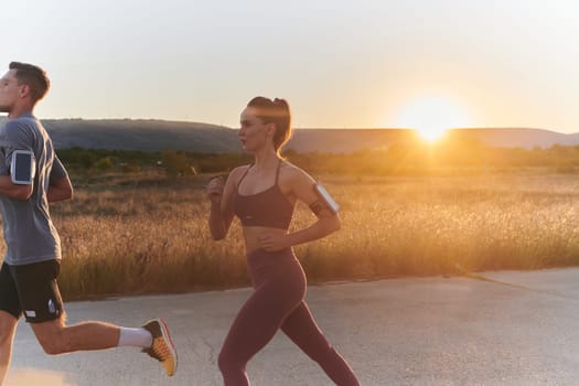 A handsome young couple running together during the early morning hours, with the mesmerizing sunrise casting a warm glow, symbolizing their shared love and vitality.