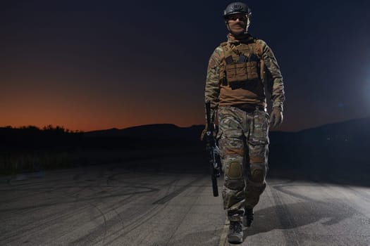 A professional soldier in full military gear striding through the dark night as he embarks on a perilous military mission.