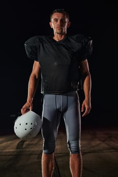 American Football Field: Lonely Athlete Warrior Standing on a Field Holds his Helmet and Ready to Play. Player Preparing to Run, Attack and Score Touchdown