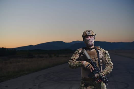 A professional soldier in full military gear striding through the dark night as he embarks on a perilous military mission.