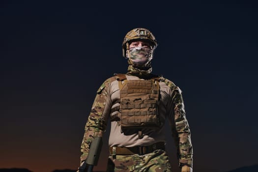 A professional soldier in full military gear striding through the dark night as he embarks on a perilous military mission.