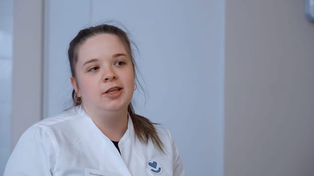 Doctor working in the office and giving recommendations to the patient. Clip. Young female doctor explaining symptoms to male patient, health care and assistance concept