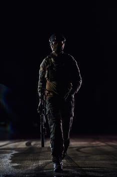 A professional soldier in full military gear striding through the dark night as he embarks on a perilous military mission.