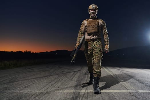 A professional soldier in full military gear striding through the dark night as he embarks on a perilous military mission.