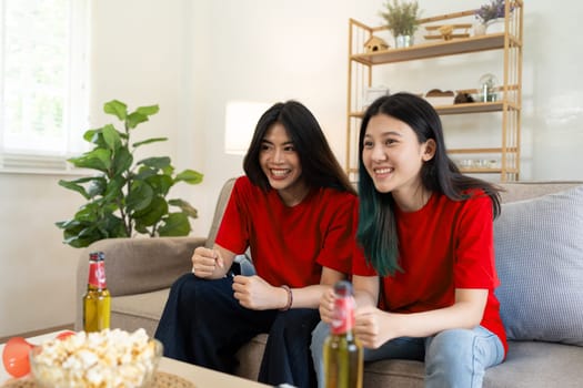 Lesbian Soccer or Sport fans emotionally watching game in the living room.