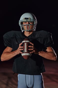 American Football Field: Lonely Athlete Warrior Standing on a Field Holds his Helmet and Ready to Play. Player Preparing to Run, Attack and Score Touchdown