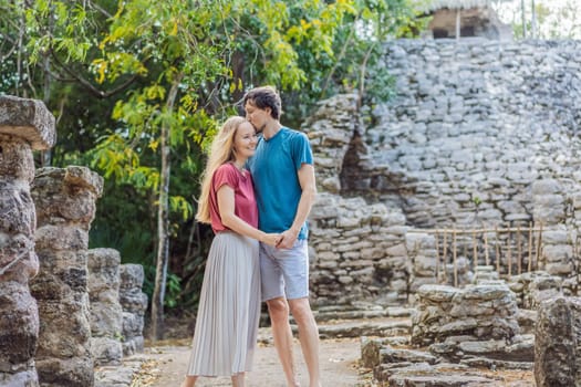 Couple, man and woman tourists at Coba, Mexico. Honeymoon Ancient mayan city in Mexico. Coba is an archaeological area and a famous landmark of Yucatan Peninsula. Cloudy sky over a pyramid in Mexico.