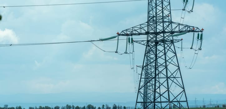 High voltage towers with sky background. Power line support with wires for electricity transmission. High voltage grid tower with wire cable at distribution station. Energy industry, energy saving.