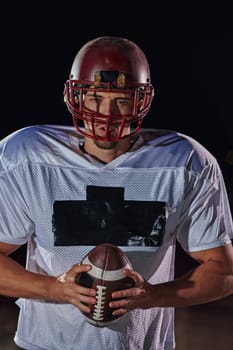 American Football Field: Lonely Athlete Warrior Standing on a Field Holds his Helmet and Ready to Play. Player Preparing to Run, Attack and Score Touchdown