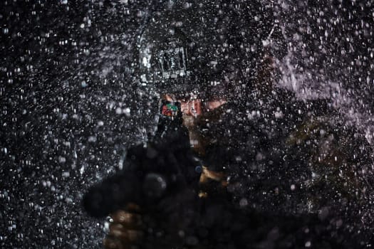 Army soldier in Combat Uniforms with an assault rifle, plate carrier and combat helmet going on a dangerous mission on a rainy night