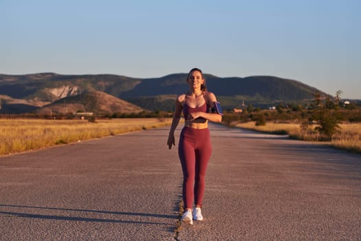 Healthy young couple jogging in the city streets in the early morning with a beautiful sunrise in the background.