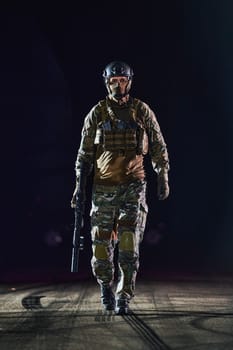 A professional soldier in full military gear striding through the dark night as he embarks on a perilous military mission.