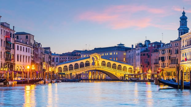 Panoramic view of famous Canal Grande with famous Rialto Bridge at sunset in Venice