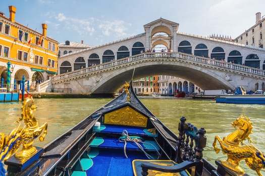 Panoramic view of famous Canal Grande with famous gondola and Rialto Bridge at sunset in Venice