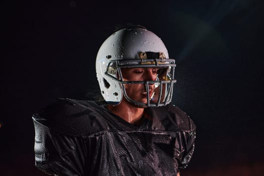 American Football Field: Lonely Athlete Warrior Standing on a Field Holds his Helmet and Ready to Play. Player Preparing to Run, Attack and Score Touchdown