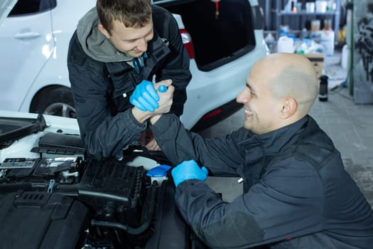 mechanic men with wrench repairing car at workshop