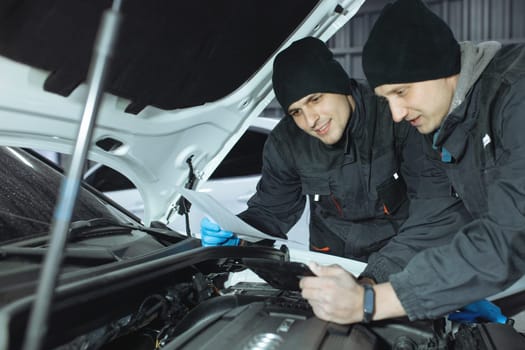 mechanic men with wrench repairing car at workshop