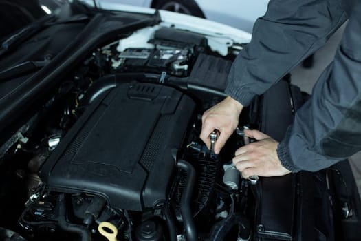 A male automech is inspecting the car's engine. Car service and car repair.