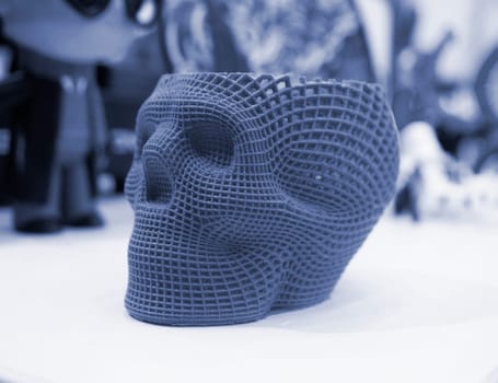 Prototype of human skull printed on 3D printer from molten purple plastic. Modern new printing manufacturing. Additive progressive medical technology. Three-dimensional model skull 3D printed close-up