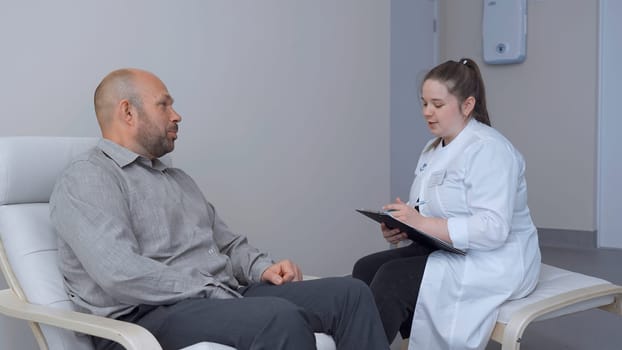 Man talks to doctor and gets tested. Clip. Female doctor discusses symptoms with patient in office. Man and doctor talk and find out disease.