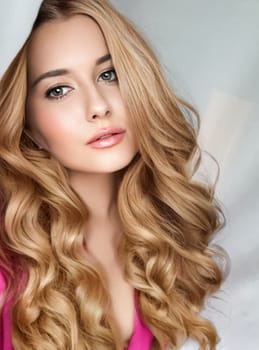 Beautiful blonde woman with curly volume hairstyle, long luxurious hair and beauty makeup, glamorous look face portrait for luxury fashion and natural cosmetics idea